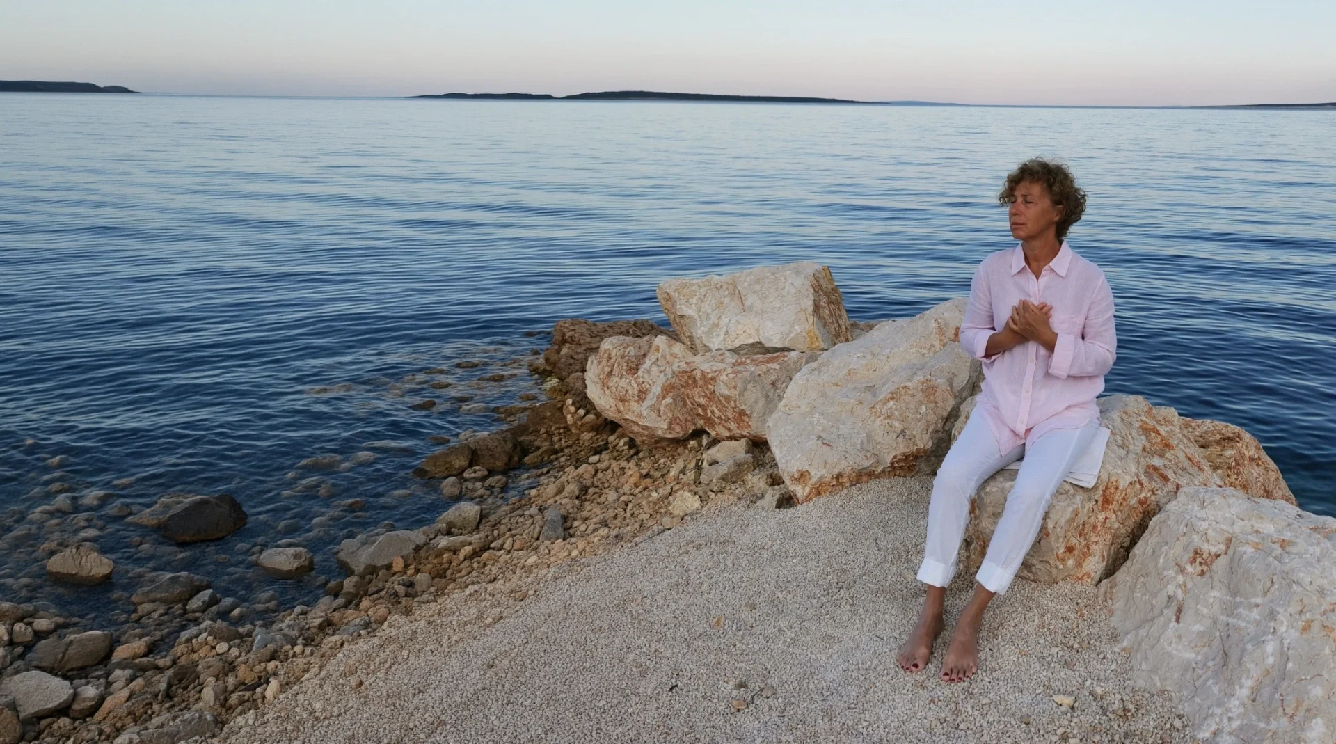 Milangela meditating by the sea at sunset